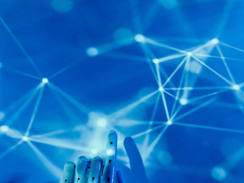 AI companies: A robotic hand touching a digital network. Photo by Tara Winstead on Pexels.
