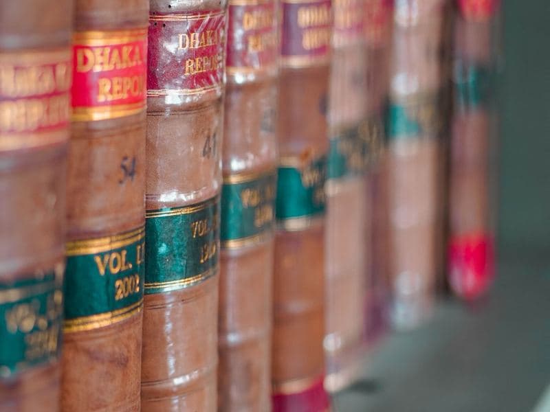 Tax & legal practices: Leather-bound law books on a shelf. Photo by Srijonism on Pexels.